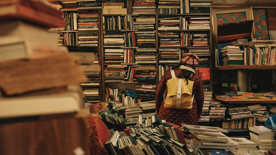 Student sucht in einer Bibliothek nach einem Buch