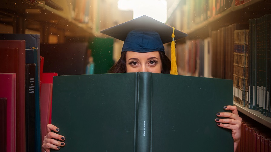 Frau hält Masterthesis vor ihrem Körper